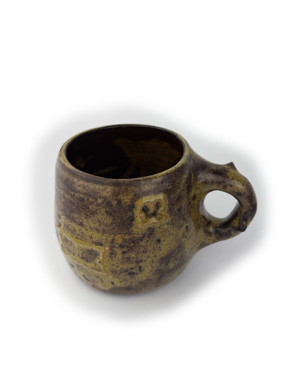 Brown ceramic mug with decorative patterns on a white background